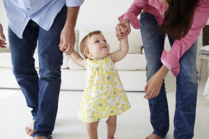 Parents teaching baby girl to walk